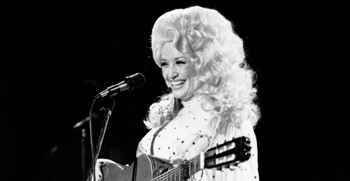 Dolly Parton performing in her signature voluminous blonde wig.